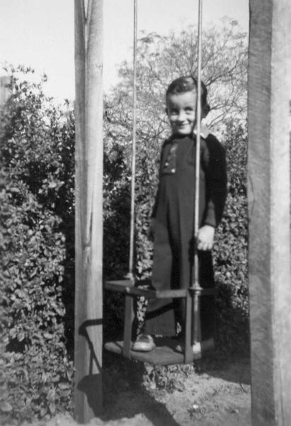 Brian Mouchemore on a swing in the backyard of 29 Richmond Street, c 1950s